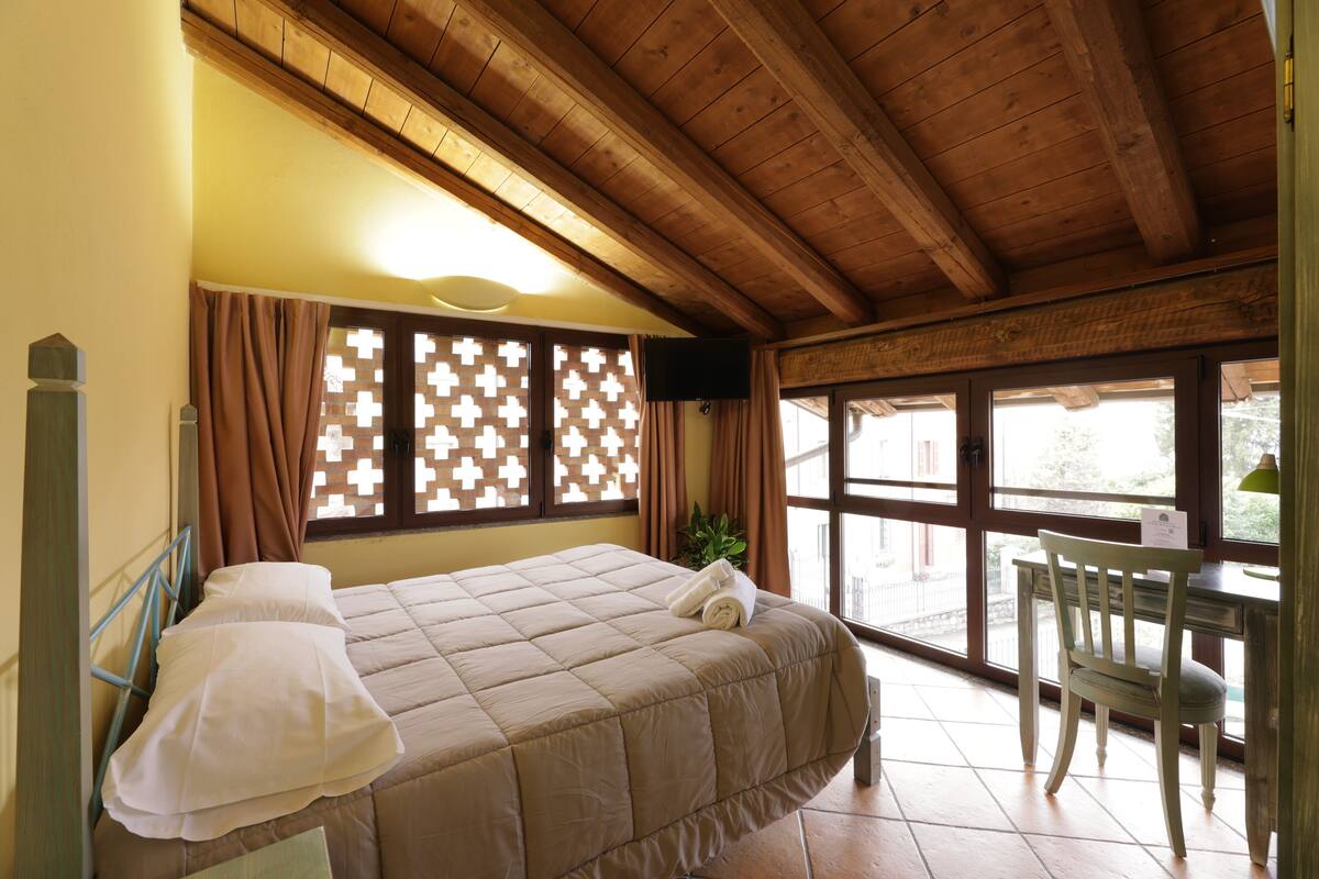 Een slaapkamer met een bed, een stoel en een bureau.
