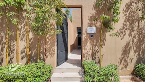 A bungalow entrance with a black gate, a sign reading "BUNGALOW Turgi", and a small security camera. - Bungalow Targa - Heated swimming pool not overlooked (Marrakech)