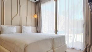 A large bed with white linens in a room with a modern design, including a unique wall paneling and a large window with sheer curtains. - Bungalow Targa - Heated swimming pool not overlooked (Marrakech)
