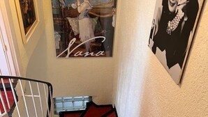 Un escalier recouvert d’une moquette rouge et sur lequel on peut lire l’inscription « Nana ».