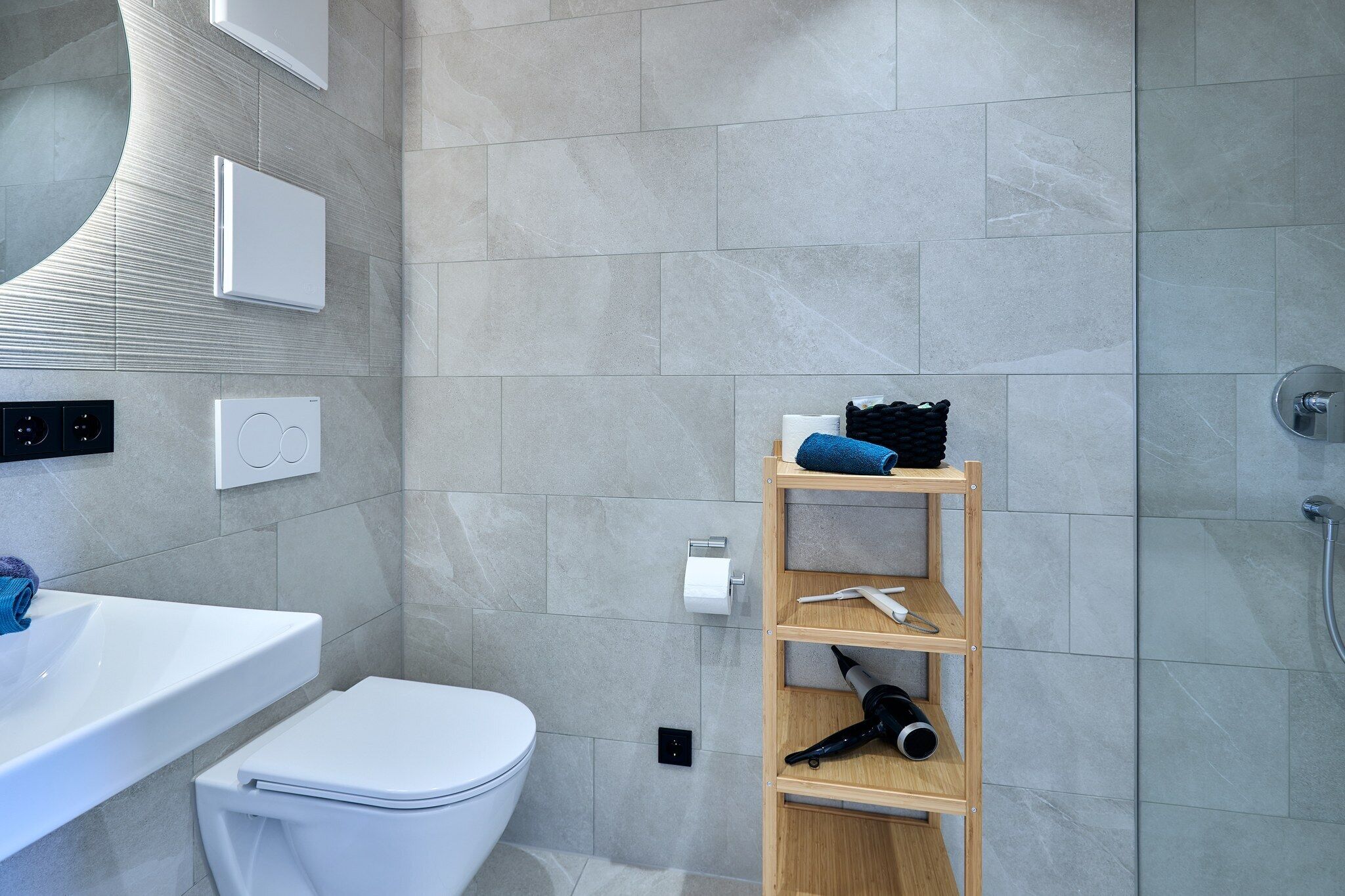 Un baño moderno con inodoro, lavamanos y ducha.