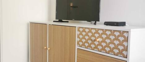 Un moble modern, de color blanc i fusta, amb un televisor de pantalla plana a la part superior.
