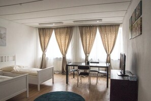 Una habitación con cama, escritorio y televisor.