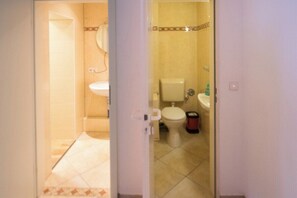 Un bagno con il water, un lavandino e una zona doccia.