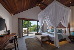 A bedroom with a canopy bed, a desk with a chair, and a view of the outdoors. - Giri Sea Cliff Penida Resort & Spa (Penida Island)