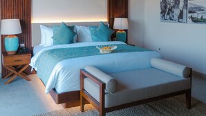 Une chambre avec un plafond en bois, un grand lit avec une tête de lit, deux tables de chevet avec des lampes et un mur orné de deux tableaux encadrés.