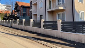 Un immeuble résidentiel à plusieurs étages, doté de balcons, d’une entrée sécurisée et surplombant un ciel dégagé.