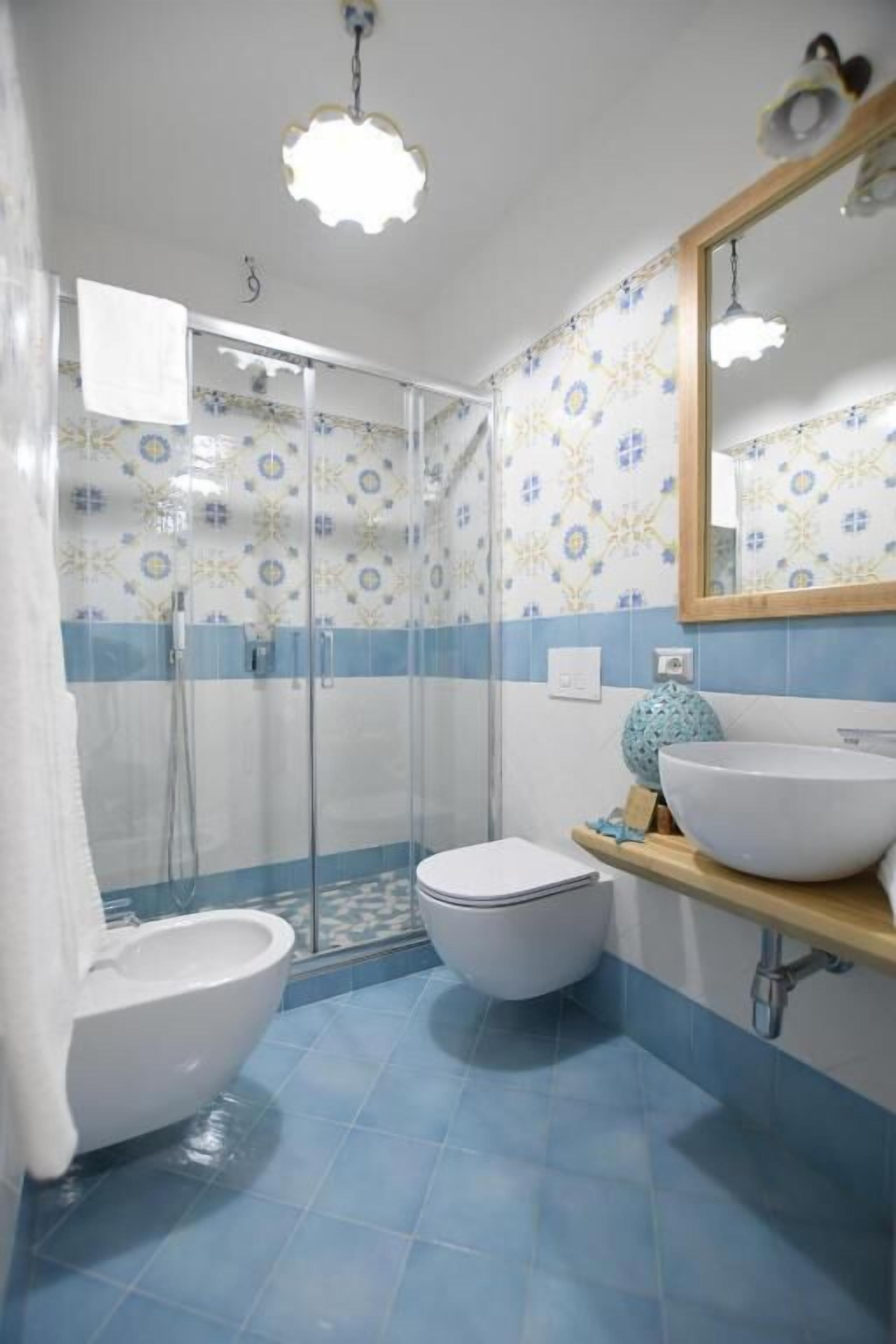 A bathroom with a shower, toilet, and sink.