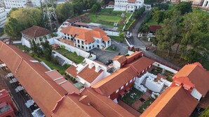 An aerial view of a historic building complex with red-tiled roofs, white walls, and a central courtyard. - Heeren Street Hotel at Jonker Walk Melaka (Malacca City)
