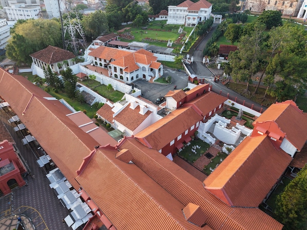 An aerial view of a historic building complex with red-tiled roofs, white walls, and a central courtyard. - Heeren Street Hotel at Jonker Walk Melaka (Malacca City)