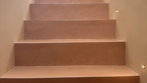 Eine Treppe mit beigeem Teppich, die zu einer höheren Etage führt.