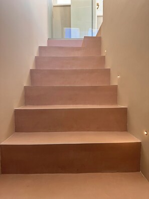 Eine Treppe mit beigeem Teppich, die zu einer höheren Etage führt.