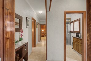 A hallway with wooden doors, a sink, and a refrigerator. - Holiday Home 'Rocamar' with Mountain View, Private Terrace and Air Conditioning (L'Escala)