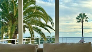 A balcony with a view of the sea, palm trees, and a white railing. - Villa Palmeras - Modern luxury with breathtaking sea view (Caleta de Vélez)