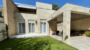 Una casa moderna de dos plantas con un porche cubierto y un césped cuidado.