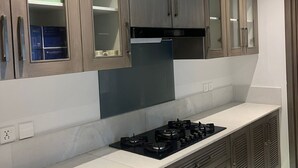 Una cocina moderna con armarios de madera, estufa a gas y campana extractora.