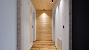 A narrow hallway with wooden panel walls and a wooden floor, leading to a dark room. - Rosenhof with whirlpool | Grüne Tanne | seeglueck (Konstanz)