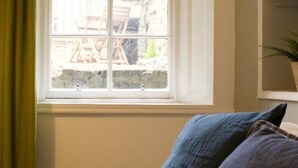 Ein Zimmer mit Fensterblick auf einen Garten.