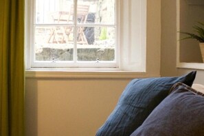 A room with a window overlooking a garden. - Main Door Flat With Private Garden City Center (Edinburgh)