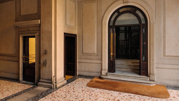 A grand hallway with a marble floor, a large arched doorway, and a wooden door. - Castello Sforzesco, Lieux Caches Undermyname (Milano)