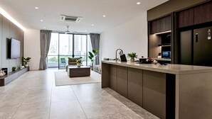 A modern kitchen with a central island, built-in appliances, and a large window providing a view of the city. - Luxury Villa Hinai by Simple Sanctuary (George Town)