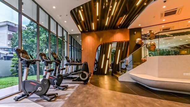 A modern gym with cardio equipment, large windows, and a curved wall design. - Luxury Villa Hinai by Simple Sanctuary (George Town)