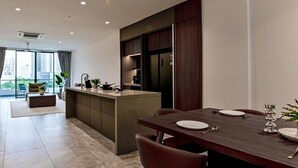 A modern kitchen with a dining area, large windows, and a view of the city. - Luxury Villa Hinai by Simple Sanctuary (George Town)