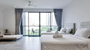A modern hotel room with a large bed, a sofa, a balcony with a view of the city, and a ceiling fan. - Luxury Villa Hinai by Simple Sanctuary (George Town)