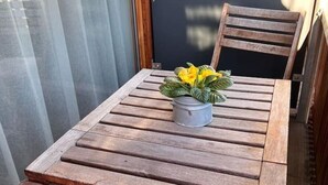 Een houten tafel met een bloempot erop.