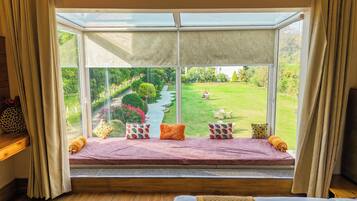 Una habitación con ventanal que da a un jardín.
