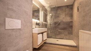Un baño moderno con ducha, inodoro y tocador.