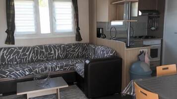 A compact living space with a sofa, a dining table, and a kitchenette.