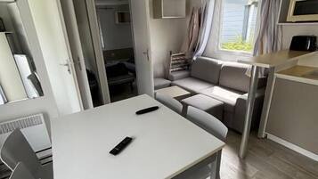 Een compact RV-interieur met een eettafel, een zitbank en een kitchenette.