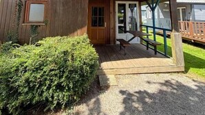 Uma cabana de madeira com varanda, porta e janela.