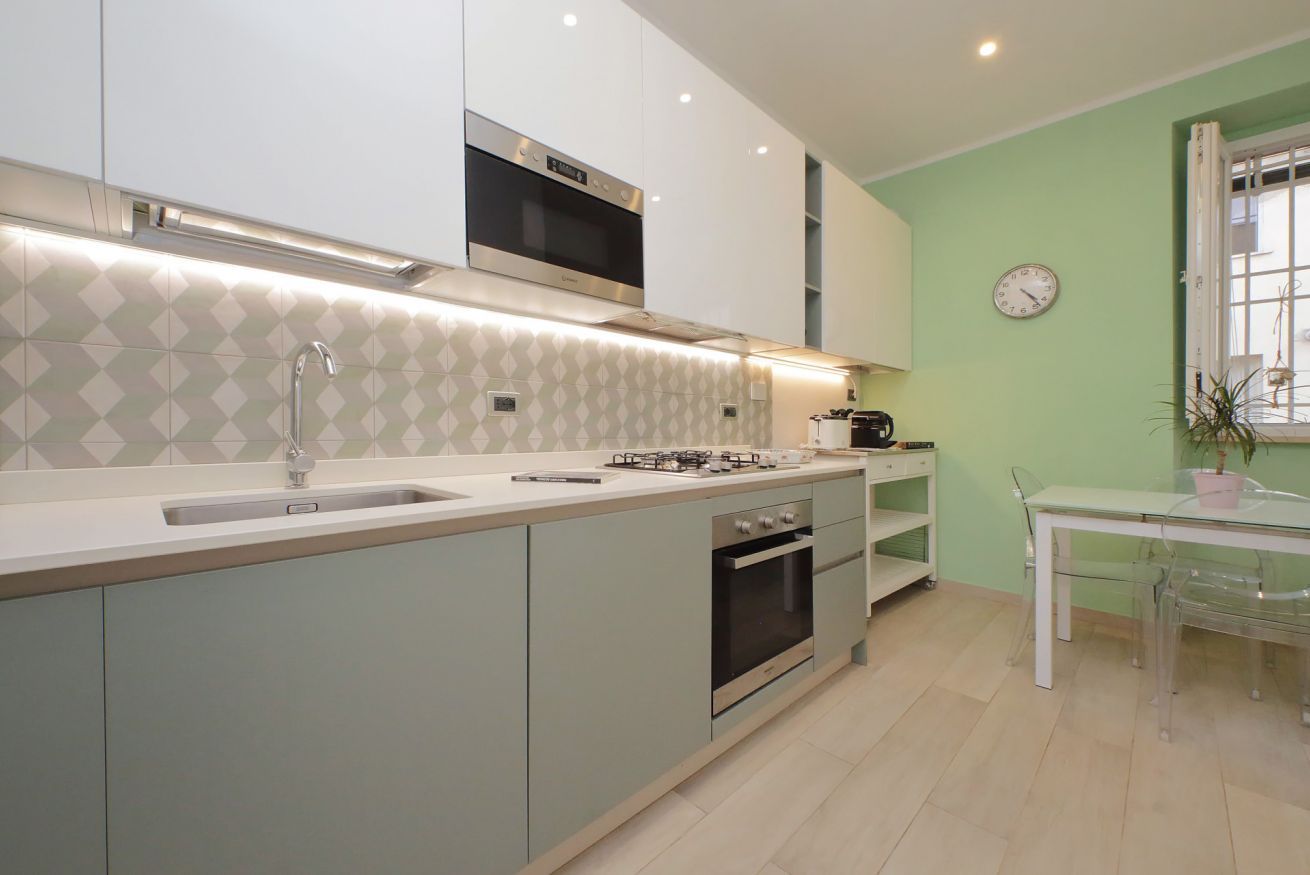 A modern kitchen with a built-in oven, a microwave, and a gas stove.