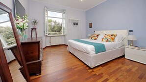 Una camera da letto con un letto, un comodino, una cassettiera, una finestra e uno specchio.