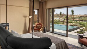 Een moderne slaapkamer met een groot bed, een plafondventilator en uitzicht op een zwembad en het landschap.