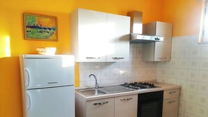 A compact kitchen with a refrigerator, stove, sink, and cabinets. - Vacation Home in Otranto with 1 bedrooms sleeps 4 (Otranto)