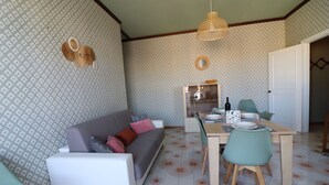 Zona pranzo con tavolo apparecchiato per quattro, circondato da sedie.