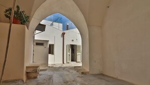 A narrow stone-paved courtyard with a high arched doorway leading to a building. - Vacation Home in Otranto with 2 bedrooms sleeps 4 (Otranto)