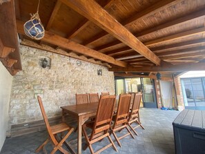 Ein rustikaler Essbereich aus Holz mit einer Steinwand und einem großen Tisch mit Stühlen.