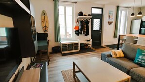 Una sala de estar moderna con un sofá, una mesa de centro y una tabla de surf en la pared.