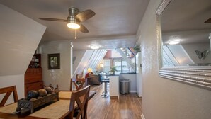 A dining area with a wooden table, chairs, and a decorative centerpiece. A ceiling fan and recessed lighting are visible. - Lake Henry A-Frame Retreat-Dock, Kayaks & Fire Pit (Lake Placid)