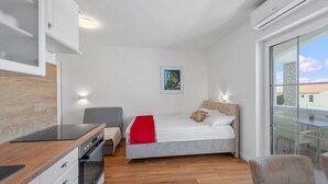 Een moderne slaapkamer met een bed, nachtkastje en uitzicht op buiten.