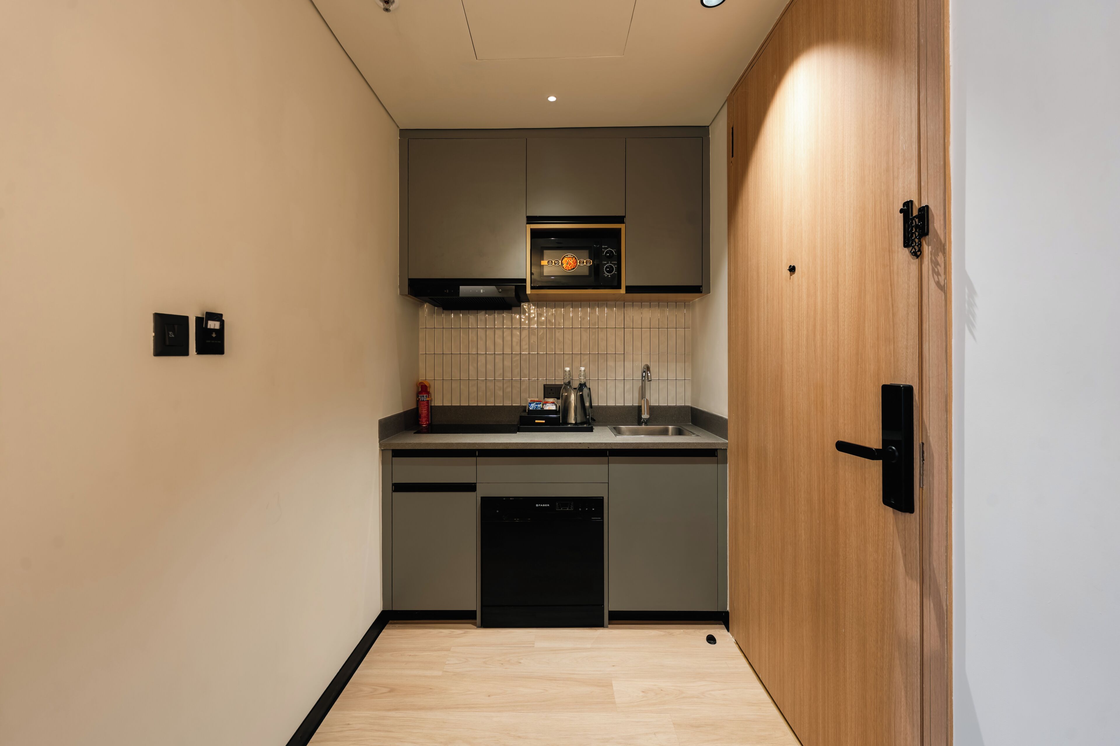 A compact kitchen with a dishwasher, a microwave, and a sink.