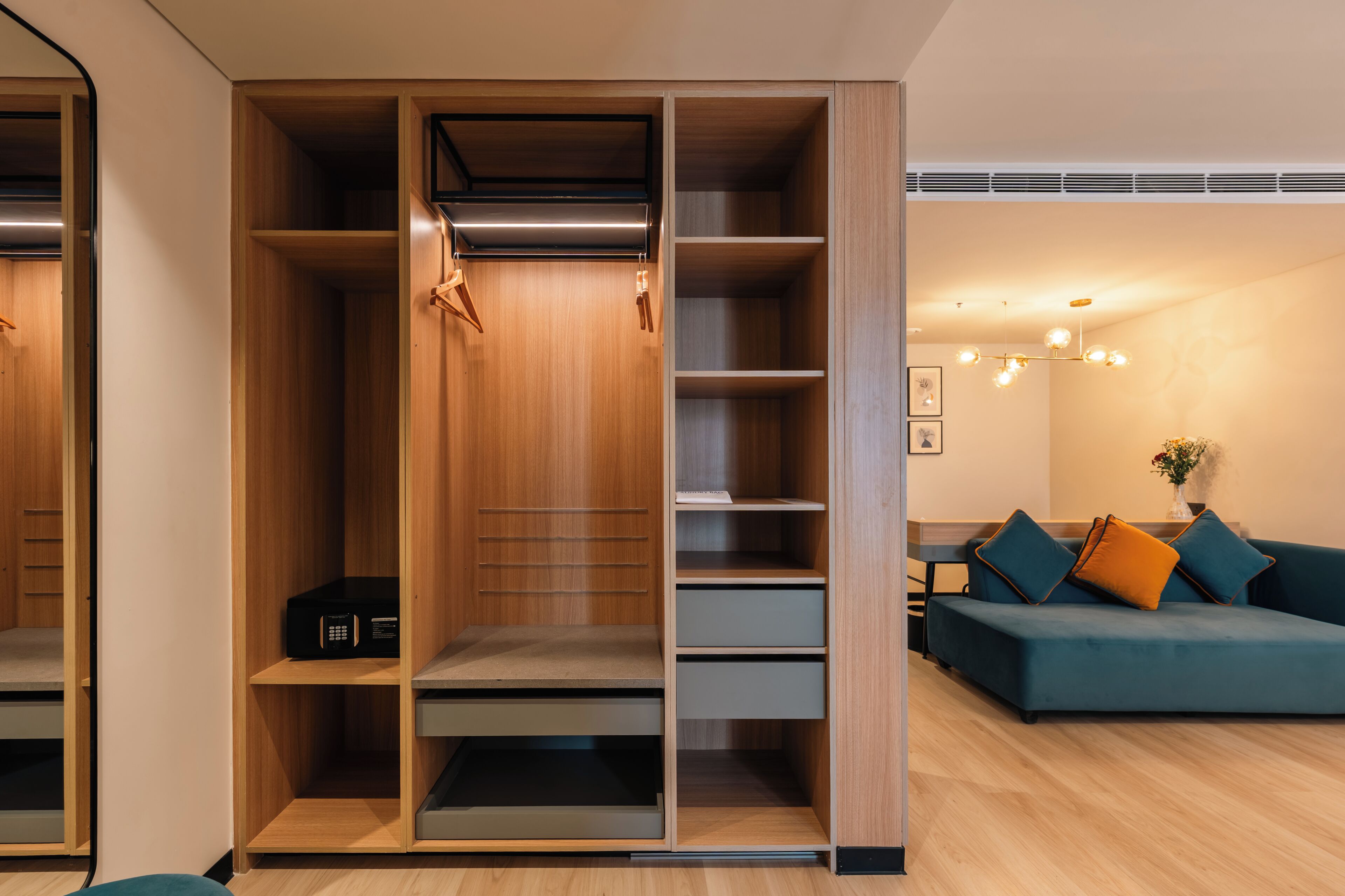 A modern interior with a wooden closet, a sofa, and a ceiling light fixture.