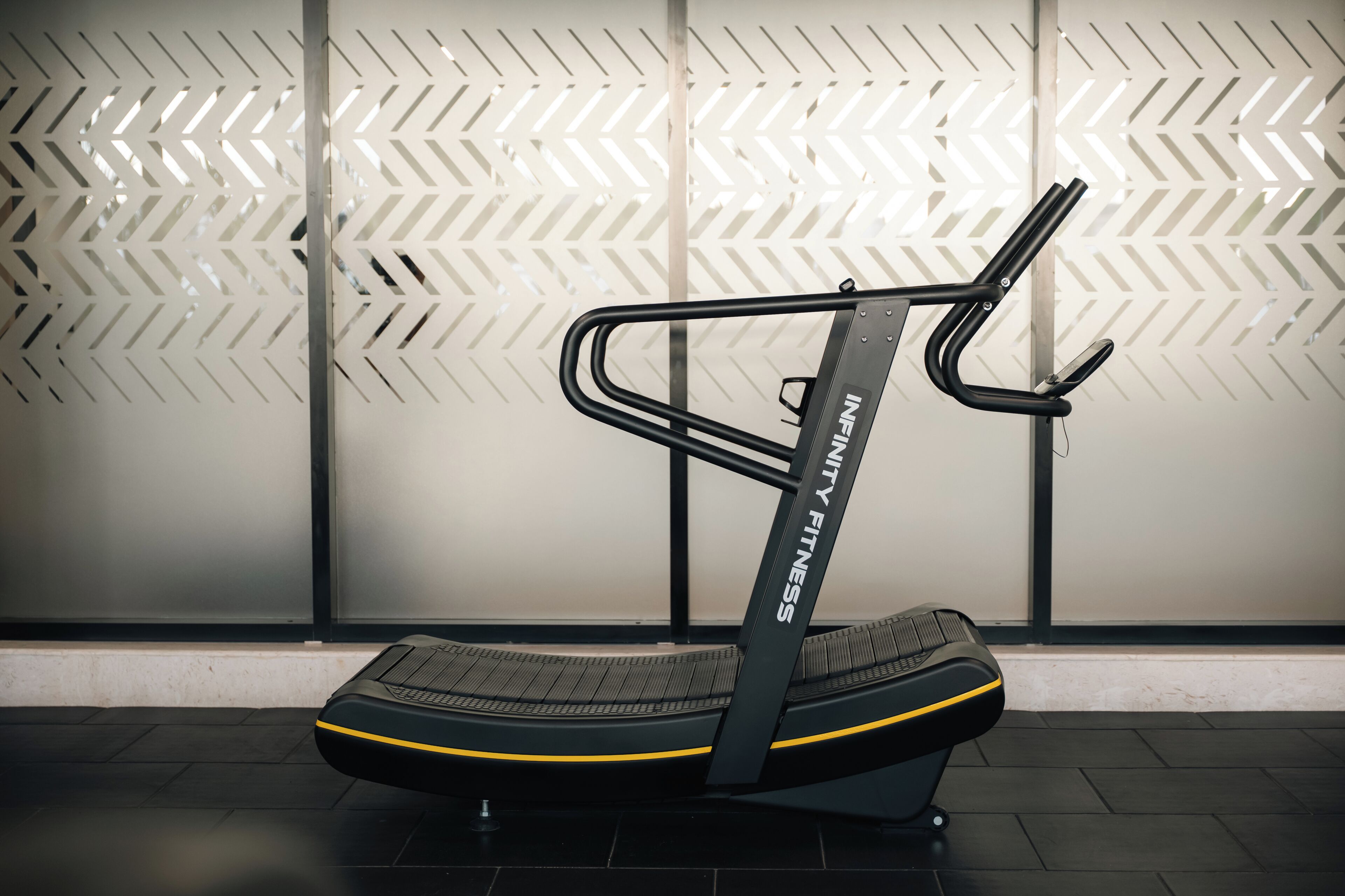 A stationary bike with the brand name 'INFINITY FITNESS' in a gym setting.