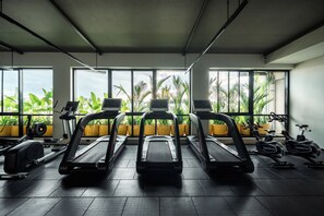 Una sala de fitness amb cintes de córrer, bicicletes estacionàries i màquines de musculació.