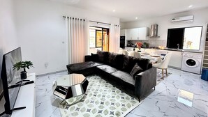 Een moderne woonkamer met een modulaire bank, een flatscreen televisie en een vloerkleed met dessin.