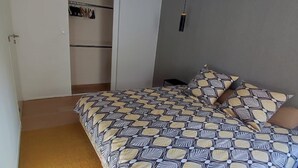 Makuuhuone, jossa on sänky, vaatekaappi ja riippuvalaisin.